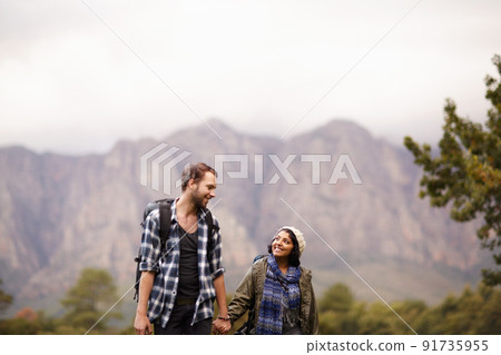 Enjoying a nature walk. Cute young couple exploring the outdoors together. 91735955