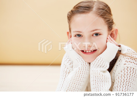 Giving you a sweet smile. Cropped portrait of a cute little girl smiling while lying on the floor. 91736177