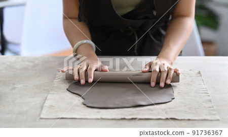 Young woman creating handmade ceramic bowl in workshop. Indoors lifestyle activity, handicraft, hobbies concept Young woman creating handmade ceramic bowl in workshop. Indoors lifestyle activity, handicraft, hobbies concept 91736367
