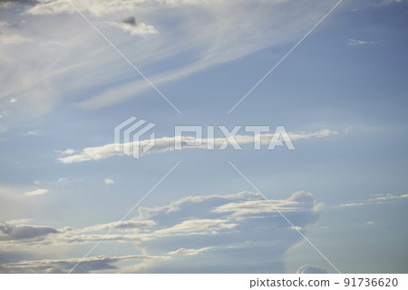Light clouds in a blue sky with copy space background. A beautiful clear summer sky with sunshine and a white soft textured cloudscape in nature. Calming skies clearing up on a sunny day 91736620