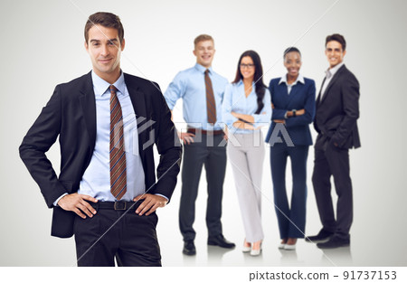 Unity through business diversity. Studio shot of a businessman with his hands on his hips standing in front of her colleagues. Unity through business diversity. Studio shot of a businessman with his hands on his hips standing in front of her colleagues. 91737153