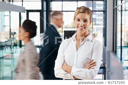 Our offices are always a hive of activity. Portrait of a young businesswoman standing in a busy office. Our offices are always a hive of activity. Portrait of a young businesswoman standing in a busy office. 91737205