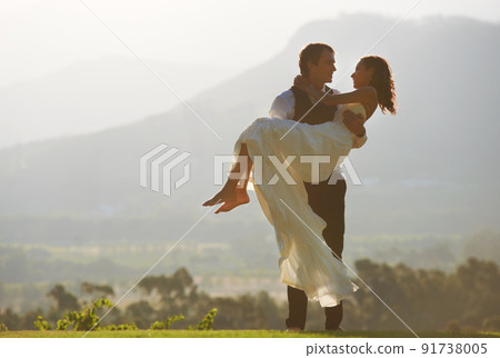 The happiest day of their lives. A groom carrying his bride. 91738005