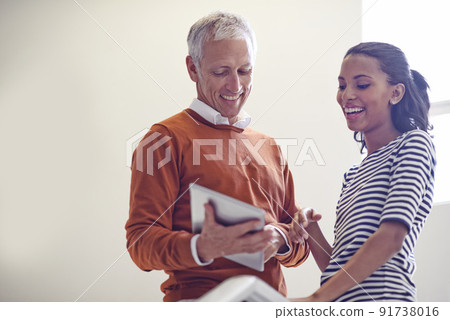 Impromptu strategy meeting. Shot of a coworkers standing in a stairwell talking over a digital tablet. Impromptu strategy meeting. Shot of a coworkers standing in a stairwell talking over a digital tablet. 91738016