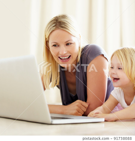 She loves watching cartoons online. Shot of a mother and daughter bonding while surfing the internet together. She loves watching cartoons online. Shot of a mother and daughter bonding while surfing the internet together. 91738088