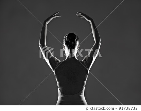 She lives to dance. Silhouette of a young ballerina dancing against a dark background. 91738732