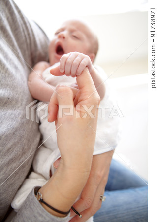 Falling asleep in her mothers arms. Shot of a newborn girl being held by her mother. Falling asleep in her mothers arms. Shot of a newborn girl being held by her mother. 91738971