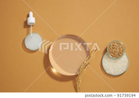Top view of rice and wheat extract in petri dish and transparent podium for cosmetic advertising light brown advertising , front view Top view of rice and wheat extract in petri dish and transparent podium for cosmetic advertising light brown advertising , front view 91739194