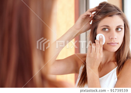 Exfoliation. A beautiful young woman cleaning her face. Exfoliation. A beautiful young woman cleaning her face. 91739539