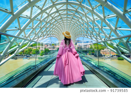 Tourist walking on bridge of peace in Tbilisi, Georgia. Tourist walking on bridge of peace in Tbilisi, Georgia. 91739585