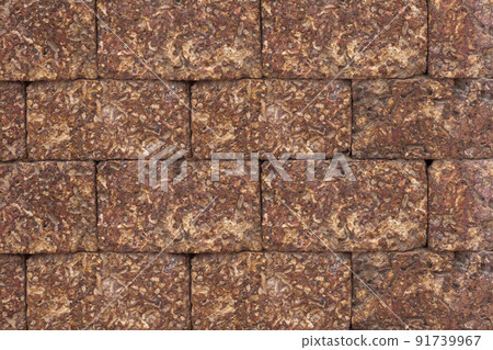 Close-up the reddish brown brick wall blocks and rough wall in background, rough texture block brown wall in background. Close-up the reddish brown brick wall blocks and rough wall in background, rough texture block brown wall in background. 91739967