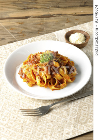 Hot bolognese with flat pasta fitcine and tomato sauce, served with parmesan cheese 91740674