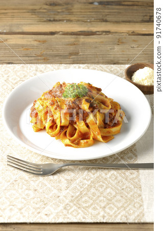 Hot bolognese with flat pasta fitcine and tomato sauce, served with parmesan cheese 91740678