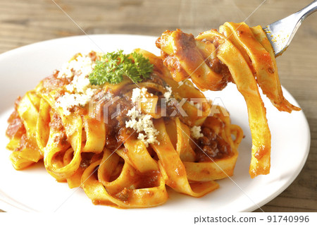 Eat parmesan cheese on hot bolognese, which is often entwined with flat pasta fitcine and tomato sauce. Eat parmesan cheese on hot bolognese, which is often entwined with flat pasta fitcine and tomato sauce. 91740996