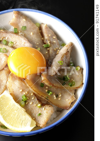 鳥瞰黑色背景中切檸檬和蛋黃的熱豬肉碗和烤肉碗 91741149