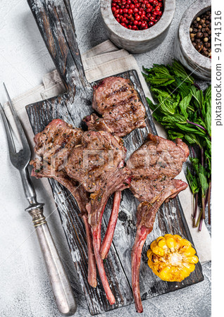 Roasted chops steaks of lamb mutton on a wooden board. White background. Top view Roasted chops steaks of lamb mutton on a wooden board. White background. Top view 91741516