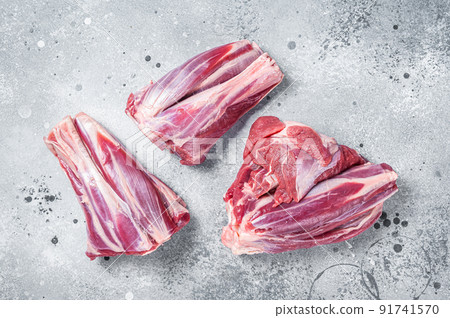 Uncooked Raw lamb shanks, mutton meat on kitchen table. Gray background. Top view Uncooked Raw lamb shanks, mutton meat on kitchen table. Gray background. Top view 91741570