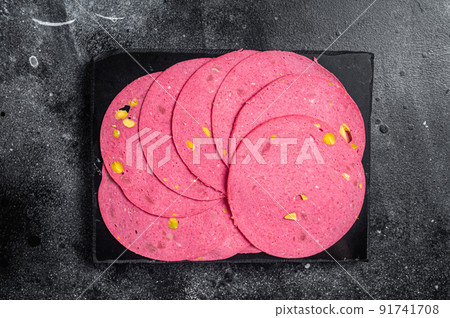 Slices of meat salami sausage with pistachios nuts on marble board. Black background. Top view Slices of meat salami sausage with pistachios nuts on marble board. Black background. Top view 91741708