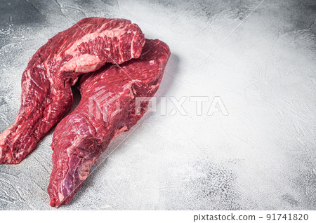 Raw tri tip beef steak on kitchen table. White background. Top view. Copy space Raw tri tip beef steak on kitchen table. White background. Top view. Copy space 91741820