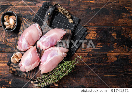 Chicken thigh fillet, Raw Boneless and skinless meat on a cutting board. Wooden background. Top view. Copy space Chicken thigh fillet, Raw Boneless and skinless meat on a cutting board. Wooden background. Top view. Copy space 91741871