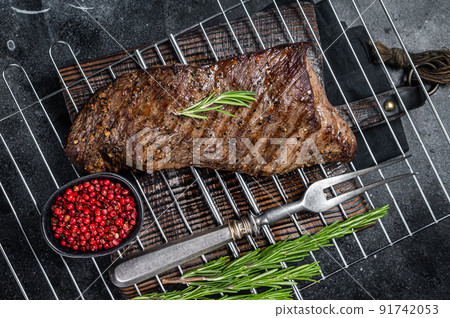 BBQ grilled tri tip beef steak on a grill. Black background. Top view 91742053