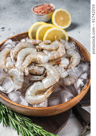 Uncooked Raw peeled tiger white shrimp prawn. Gray background. Top view Uncooked Raw peeled tiger white shrimp prawn. Gray background. Top view 91742059