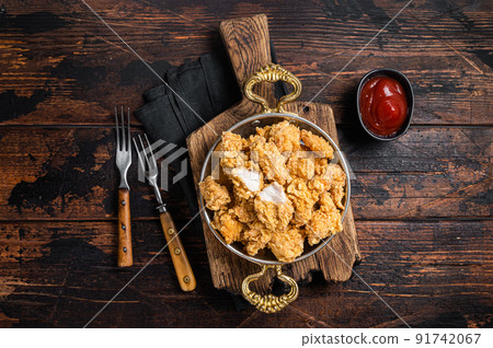 Homemade Crispy Popcorn Chicken bites in a skillet. Wooden background. Top view 91742067