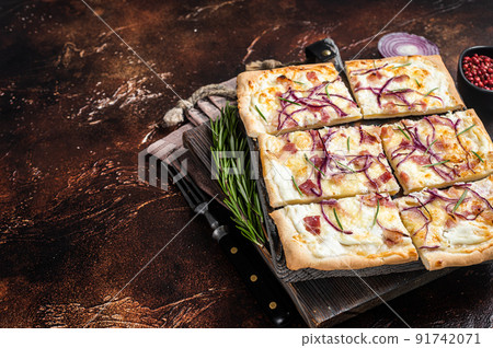 French tarte flambee with cream cheese, bacon and onions. Flammkuchen from Alsace region. Dark background. Top view. Copy space French tarte flambee with cream cheese, bacon and onions. Flammkuchen from Alsace region. Dark background. Top view. Copy space 91742071