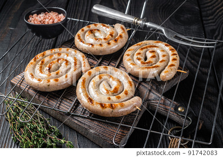 BBQ grilled spiral pork meat sausages on a grill. Black background. Top view BBQ grilled spiral pork meat sausages on a grill. Black background. Top view 91742083