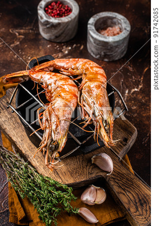 BBQ roasted Giant shrimps Langoustine on grill with herbs. Dark background. Top view BBQ roasted Giant shrimps Langoustine on grill with herbs. Dark background. Top view 91742085