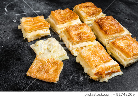 Turkish Su Boregi, Tabla borek or burek with cheese. Black background. Top view 91742209