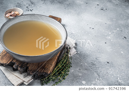 Bone meat chicken broth in a plate. Gray background. Top view. Copy space 91742396