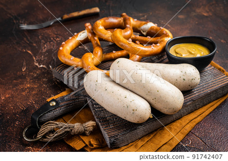 Traditional German pretzel with white sausage and mustard. Dark background. Top view 91742407
