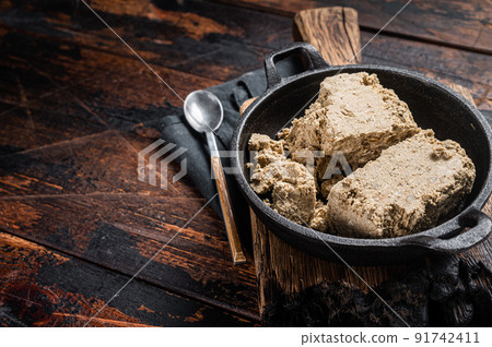 Halva with sunflower seeds and honey in pan. Wooden background. Top view. Copy space Halva with sunflower seeds and honey in pan. Wooden background. Top view. Copy space 91742411