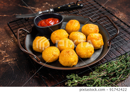 Potato croquettes, mashed potatoes balls breaded and deep fried. Dark background. Top view 91742422