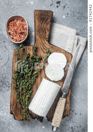 Fresh goat soft cheese with thyme. Gray background. Top view Fresh goat soft cheese with thyme. Gray background. Top view 91742442