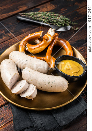 Munich white sausage with pretzel and mustard. Wooden background. Top view 91742444