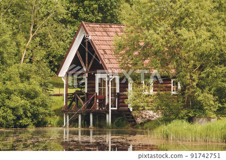 Red holiday cabin with reflection in the pond 91742751