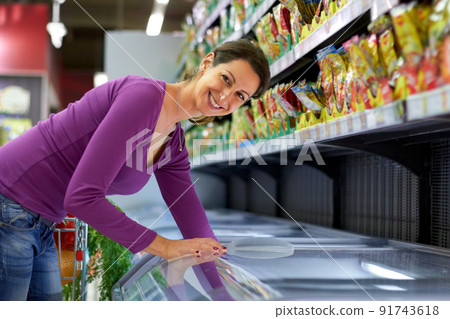Frozen is still fresh. Cropped shot of an attractive woman leaning into a freezer at a grocery store. Frozen is still fresh. Cropped shot of an attractive woman leaning into a freezer at a grocery store. 91743618