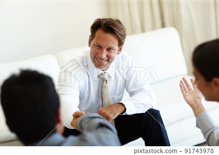 Good to see you here. Shot of three coworkers sitting down at a meeting. 91743978