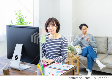 Housewife working on a computer at a table at home 91744462