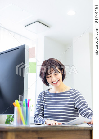 在家裡的桌子上用電腦工作的家庭主婦 91744463