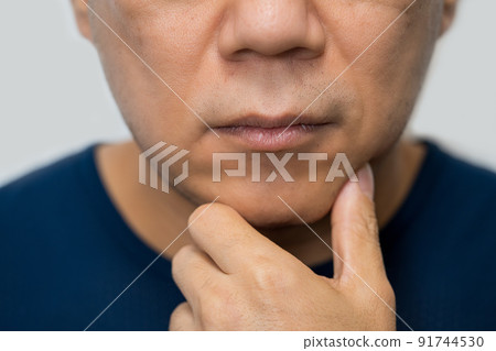 一個男人在他的下巴上打他的手 91744530