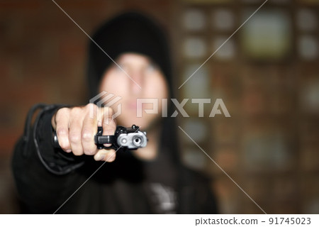 Criminal in control. View of a man holding a gun and pointing at you. Criminal in control. View of a man holding a gun and pointing at you. 91745023