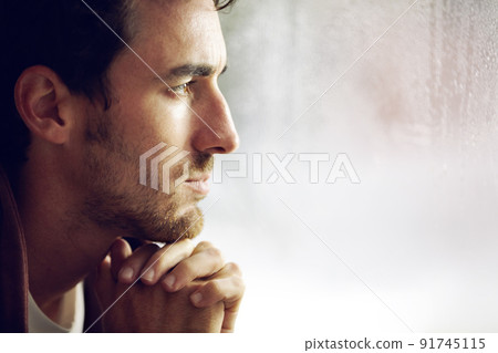 Thinking things over. A young man looking thoughtful as looks into the distance. 91745115