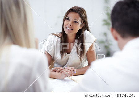 Taking her clients concerns into consideration. A pretty financial advisor listening to her clients intently. 91745243