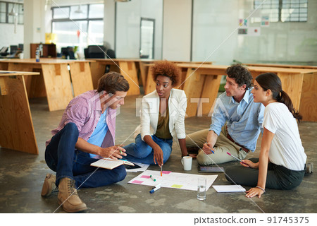 Together everyone achieves more. Shot of a group of designers working together on a office floor. Together everyone achieves more. Shot of a group of designers working together on a office floor. 91745375