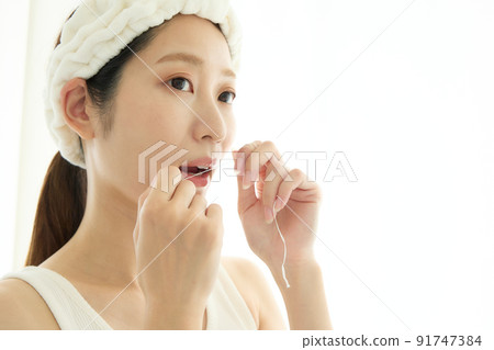 一個女人在浴室裡做牙線 91747384