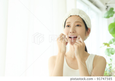 一個女人在浴室裡做牙線 91747385
