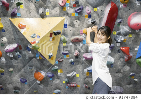 Young woman bouldering Young woman bouldering 91747884